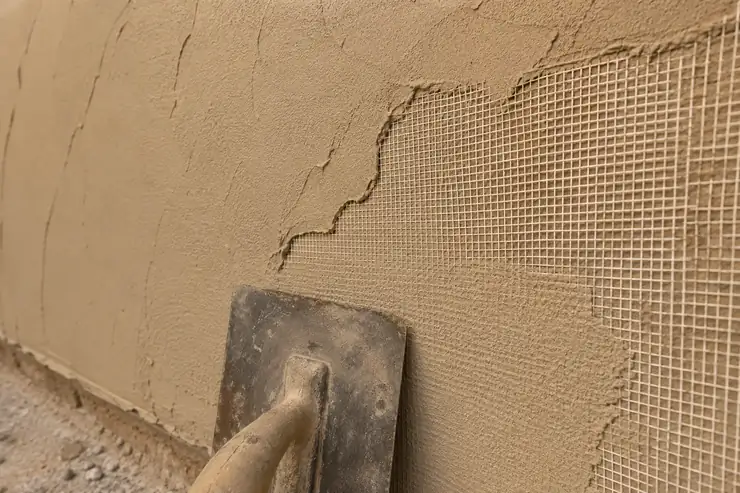 Trame en fibre de verre marouflée dans un enduit armé anti-fissures à la taloche